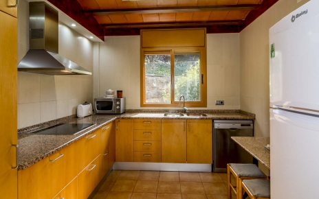 Cocina acogedora tiene mesa de desayuno